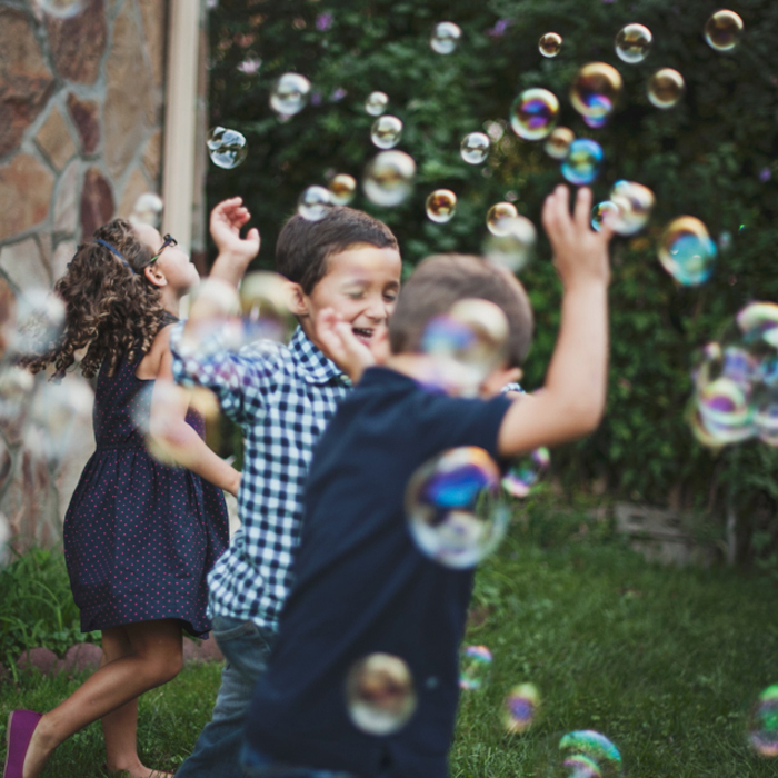 Play therapy represented by a picture of children playing amongst bubbles